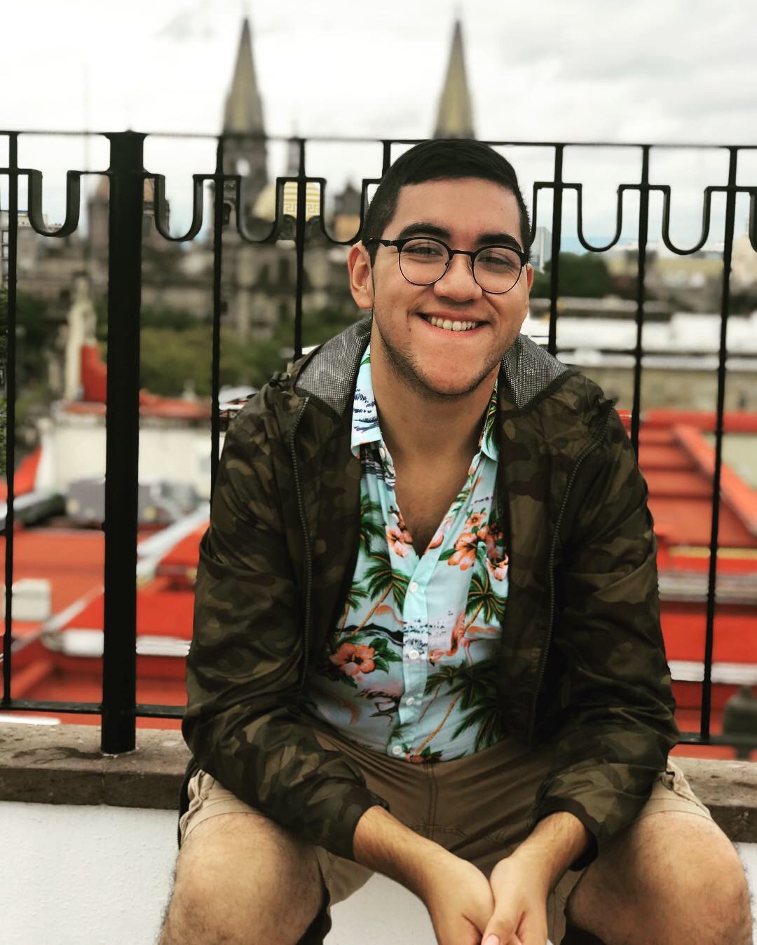 Professional photo of Fernando sitting by a fence.